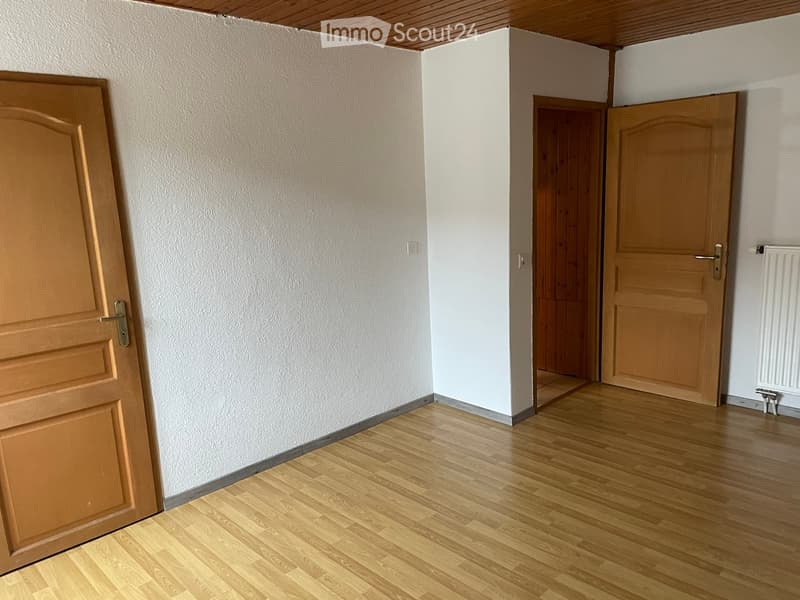 room with wooden floors, white walls, 2 doors, power outlets, heater