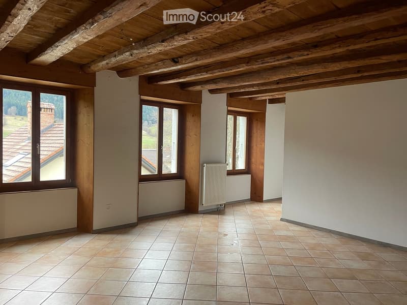 Exposed wooden ceiling, tiled flooring, windows, radiator