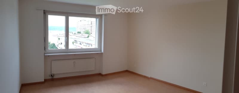 empty room, white walls, wooden floor, large window, white radiator