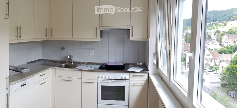 modern kitchen with white cabinets, granite countertop, white appliances, large window with view