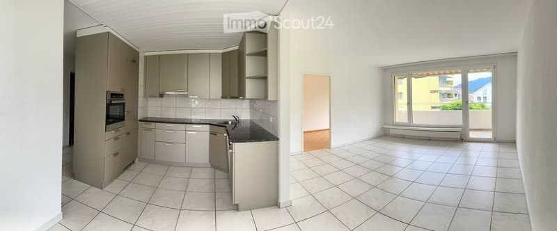 modern kitchen with white tiles, built-in appliances, open to living area