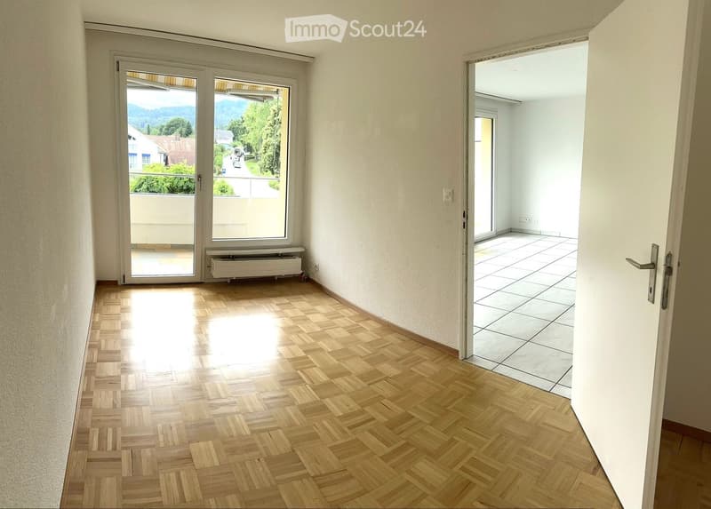 empty room, wooden parquet floor, sliding glass doors, balcony, white walls, white tiles, view of mountains