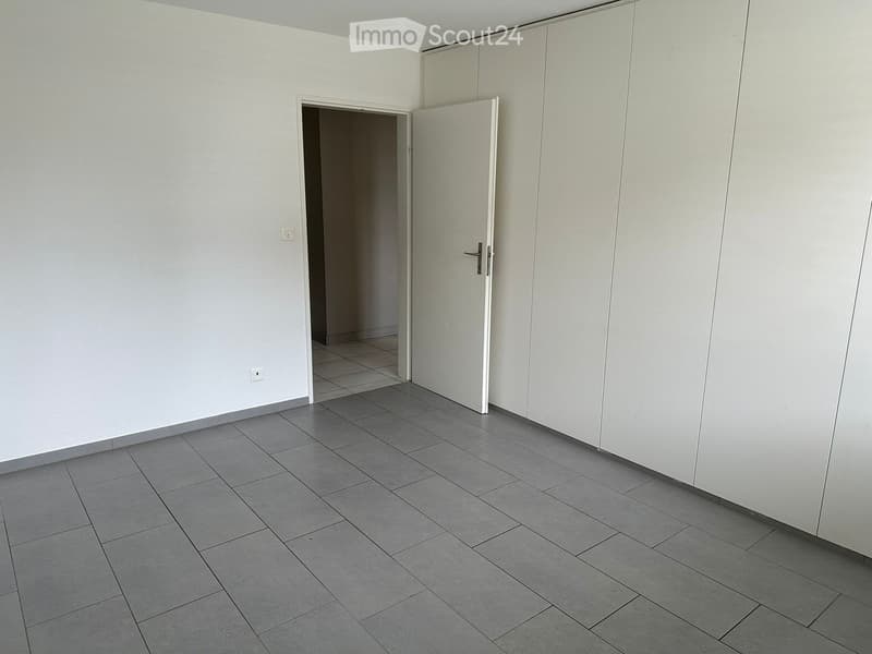 empty room, white walls, gray tile floor, open door, power outlet, closet