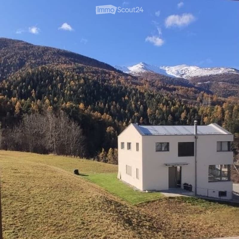 House. Modern white house with a flat roof, set in a mountainous landscape with snow-capped peaks.