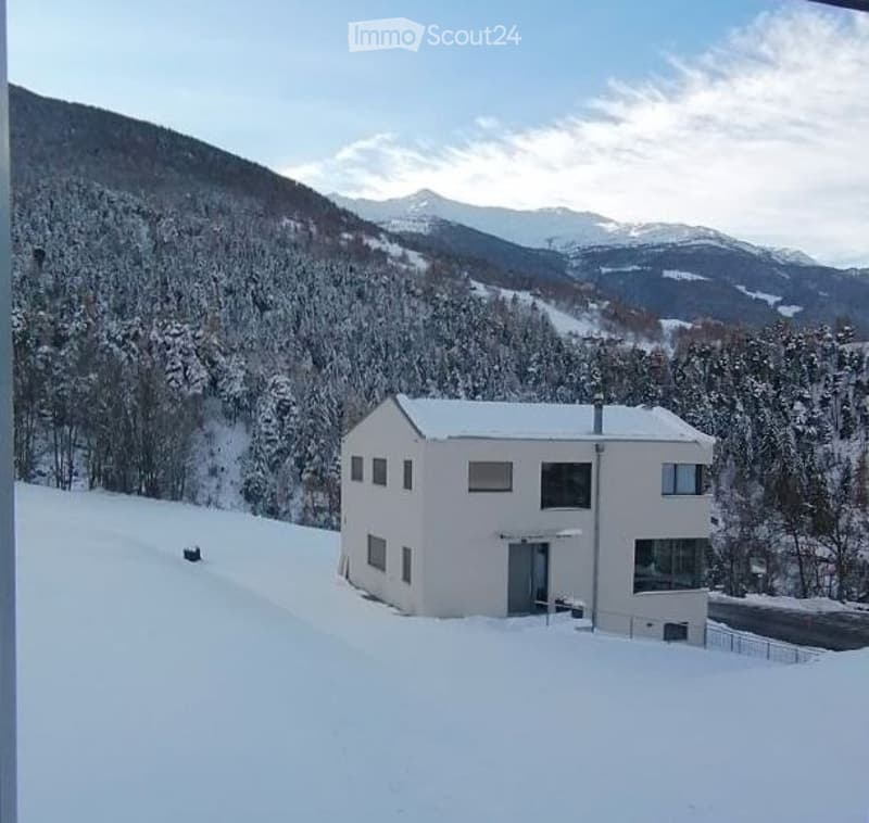 House. Modern white house on a snowy mountain slope with a clear view of the mountains.