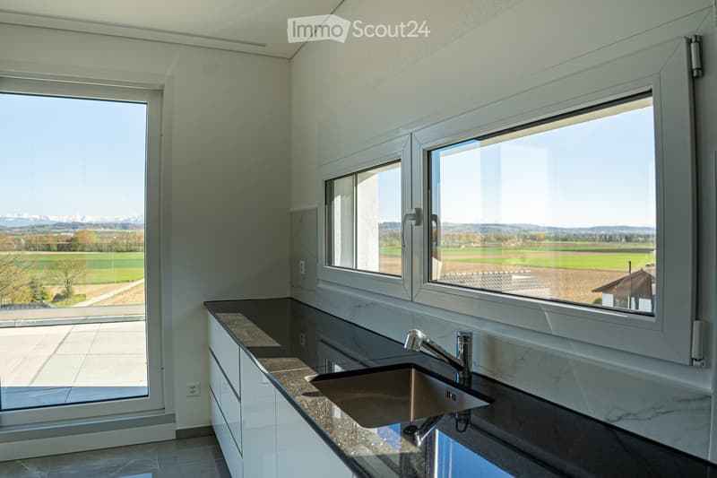 modern kitchen with granite countertops, stainless steel sink, faucet, large windows, sliding door, view of the countryside