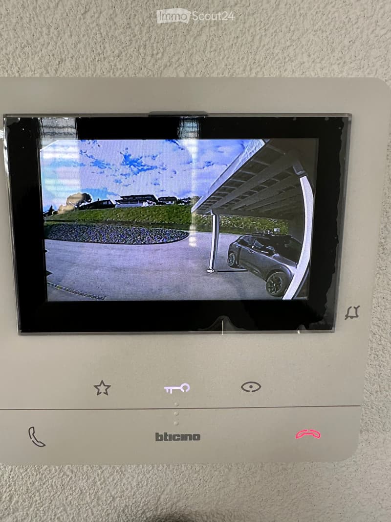 Video monitor with a live feed of a car entering a parking lot