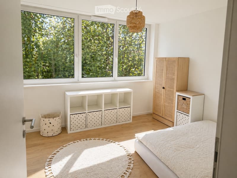 bedroom with bed, storage boxes, round rug, wooden floor, large windows, wooden cabinet, lamp