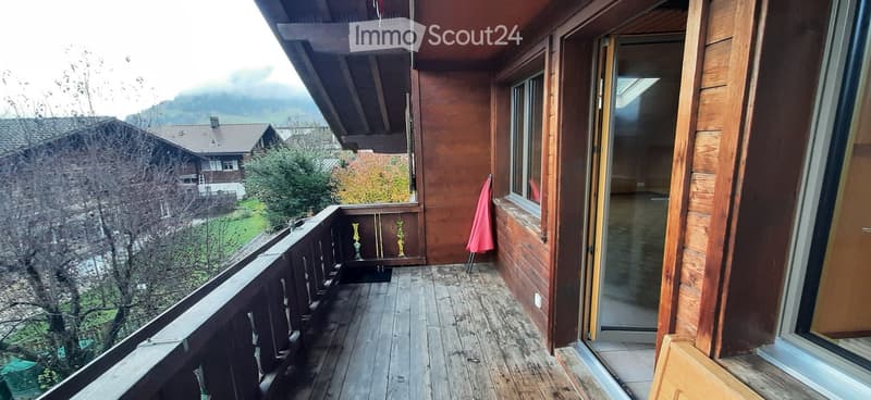 wooden balcony, wooden railing, glass door, glass window, red towel, wooden floor