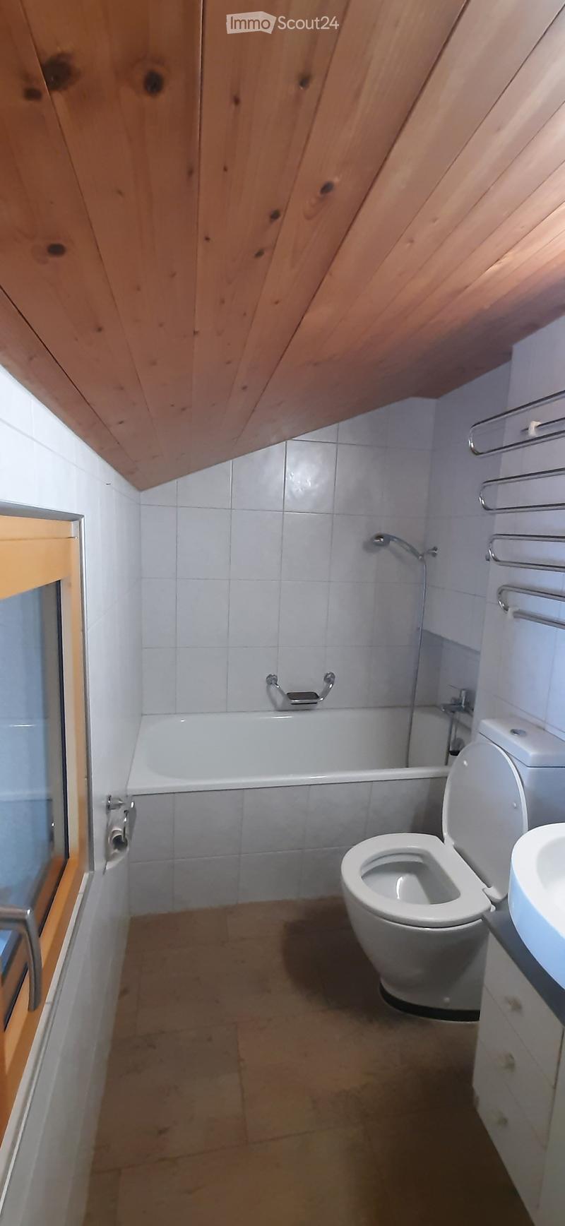 white tiles, wooden ceiling, bathtub, toilet, sink, towel rack