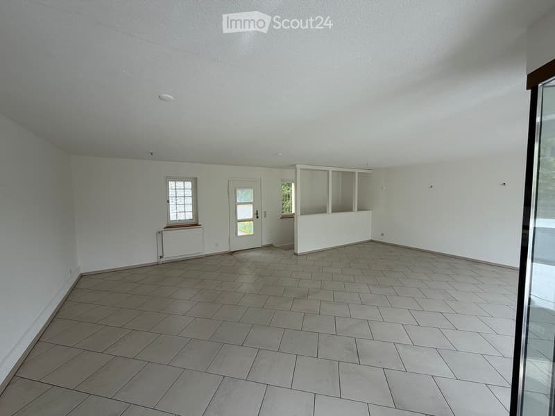 Empty room with white walls, tiled floor, two windows, and a door.
