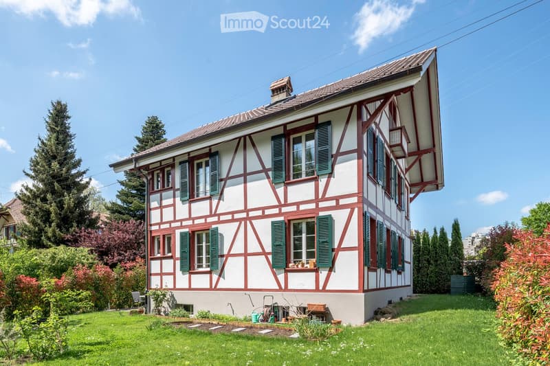 2 story house, white and red exterior, green shutters, raised ground floor, garden, trees