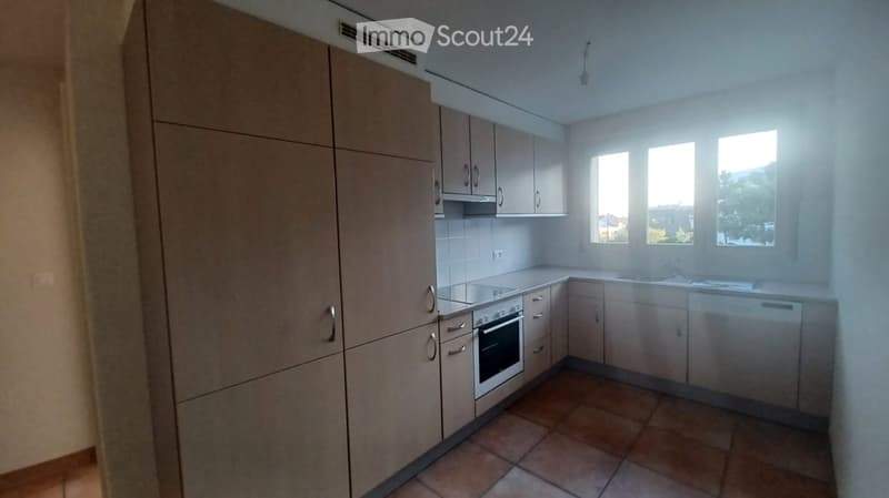 kitchen with built-in appliances, tiled floor, wooden cabinets, windows