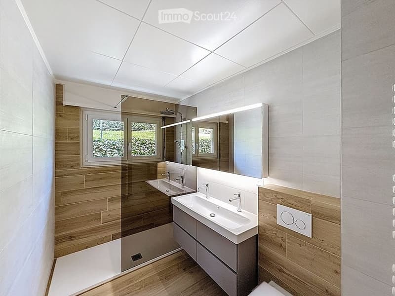 modern bathroom with wooden wall, white sink, mirror, shower, toilet