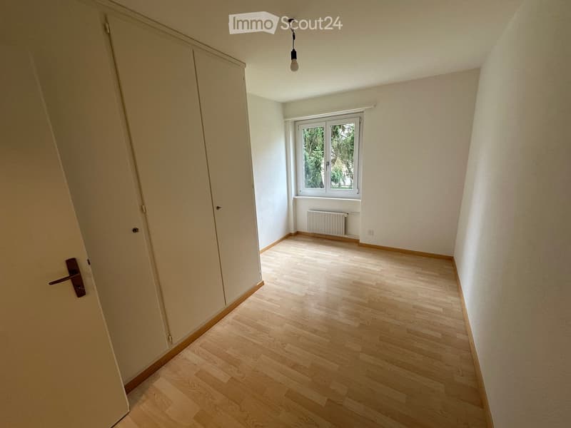 empty room, wooden floor, large window, wardrobe, white walls, white door, radiator