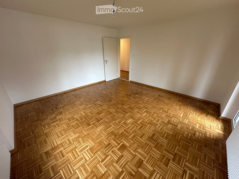 empty room, white walls, wooden parquet floor, open door
