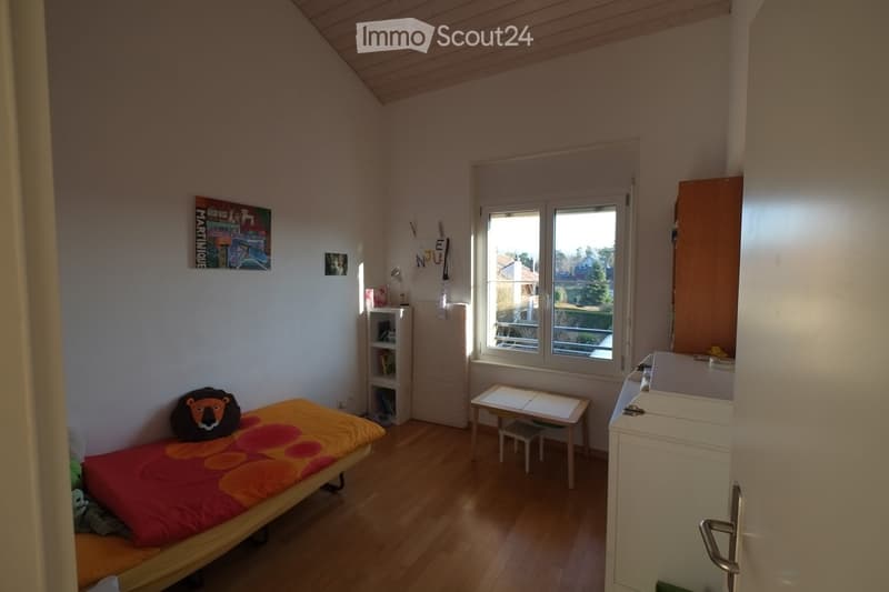 small room with bed, desk, chair, shelves, window