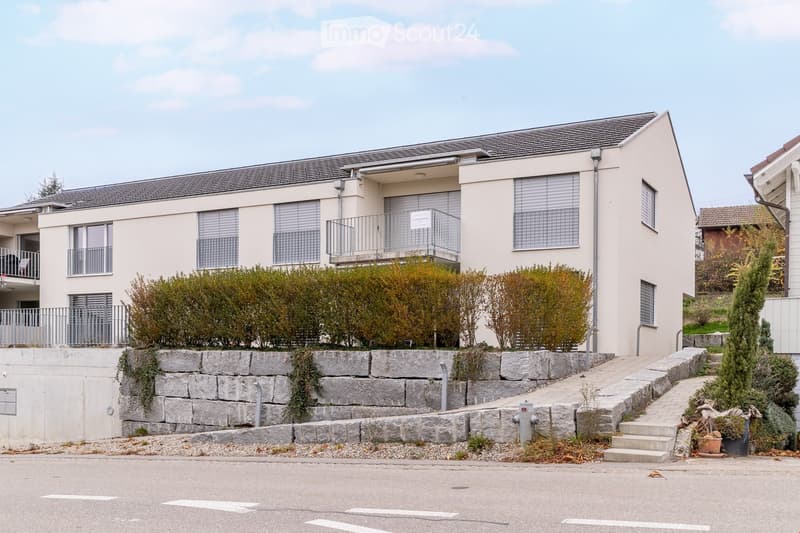 2 story house, white exterior, gray roof, balcony, stone wall, stairs, plants