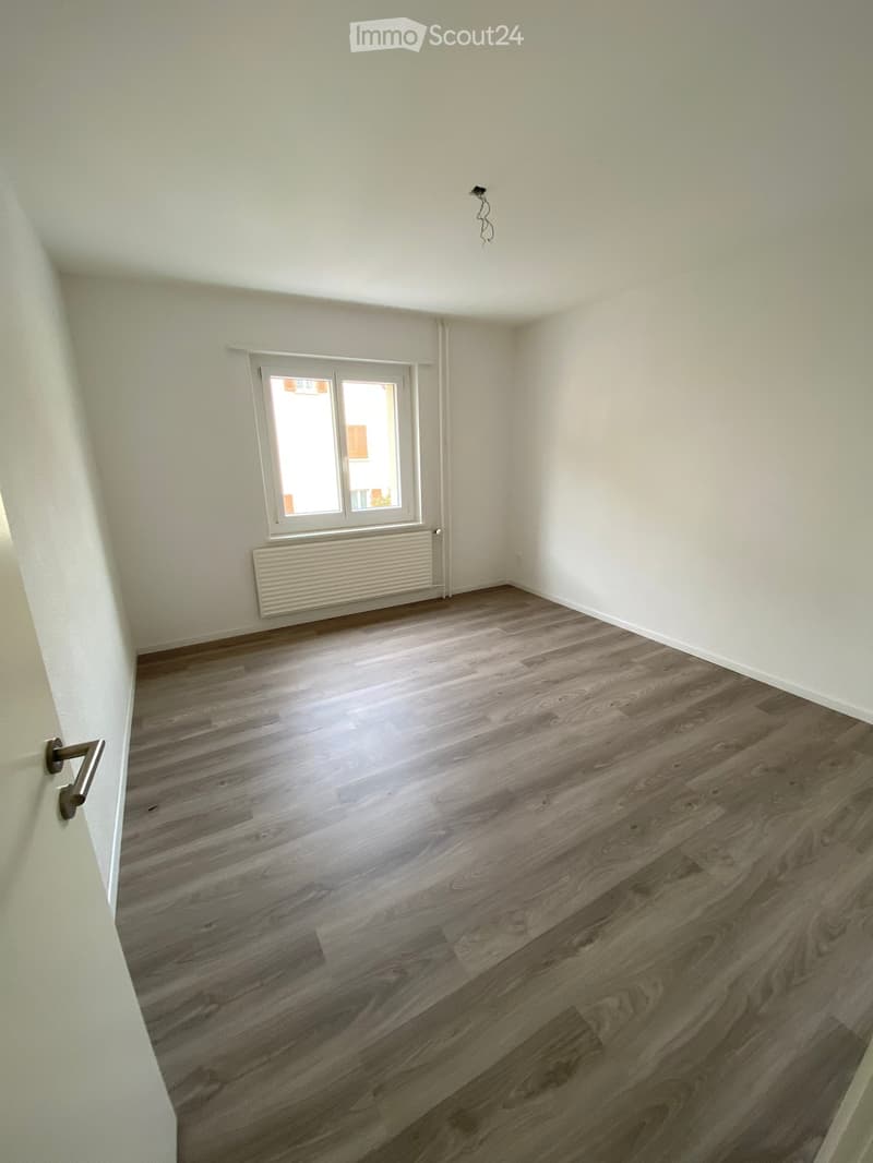 empty room, white walls, wooden floor, window, radiator