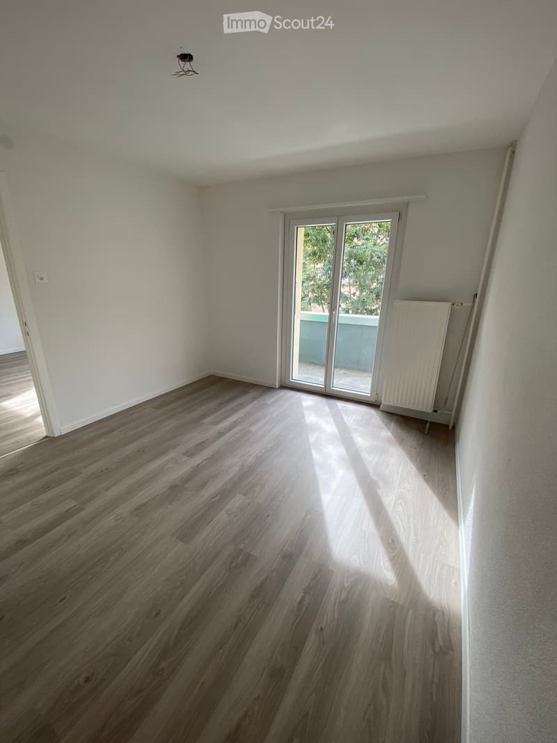 empty room, wooden floor, sliding glass door, white walls, balcony, radiator