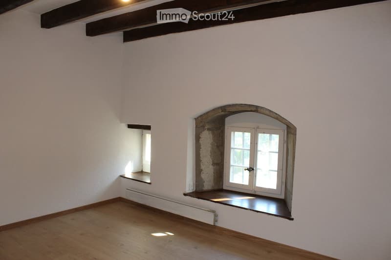 empty room, wooden floor, white walls, arched window, wooden beams