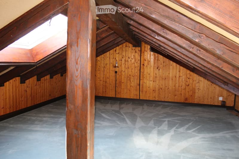 Unfurnished Room. Empty attic room with wooden beams, wooden walls, and a concrete floor.