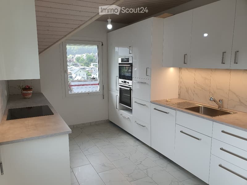 Kitchen. Modern kitchen with white cabinets, marble countertops, induction cooktop, and built-in oven and microwave.
