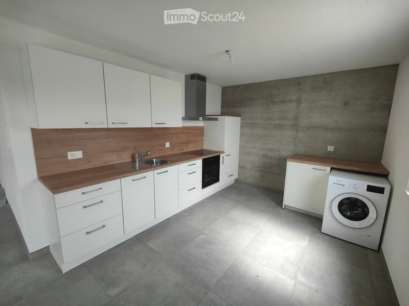 modern kitchen with white cabinets, wooden countertops, stainless steel sink, dishwasher, washing machine, gray tiled floor