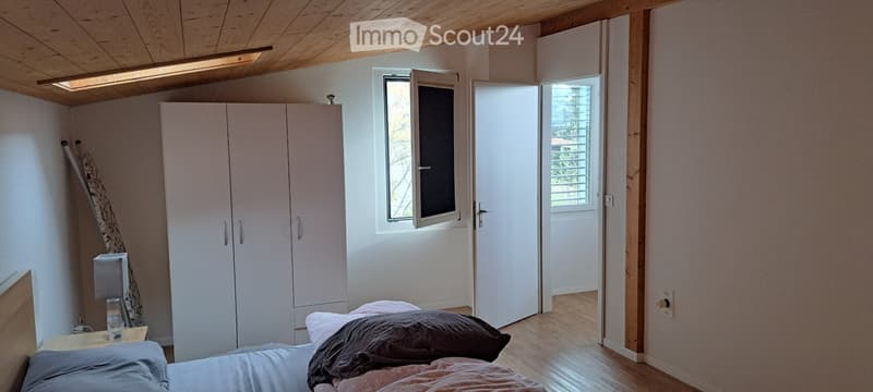 Bedroom with bed, wardrobe, window, and wooden ceiling