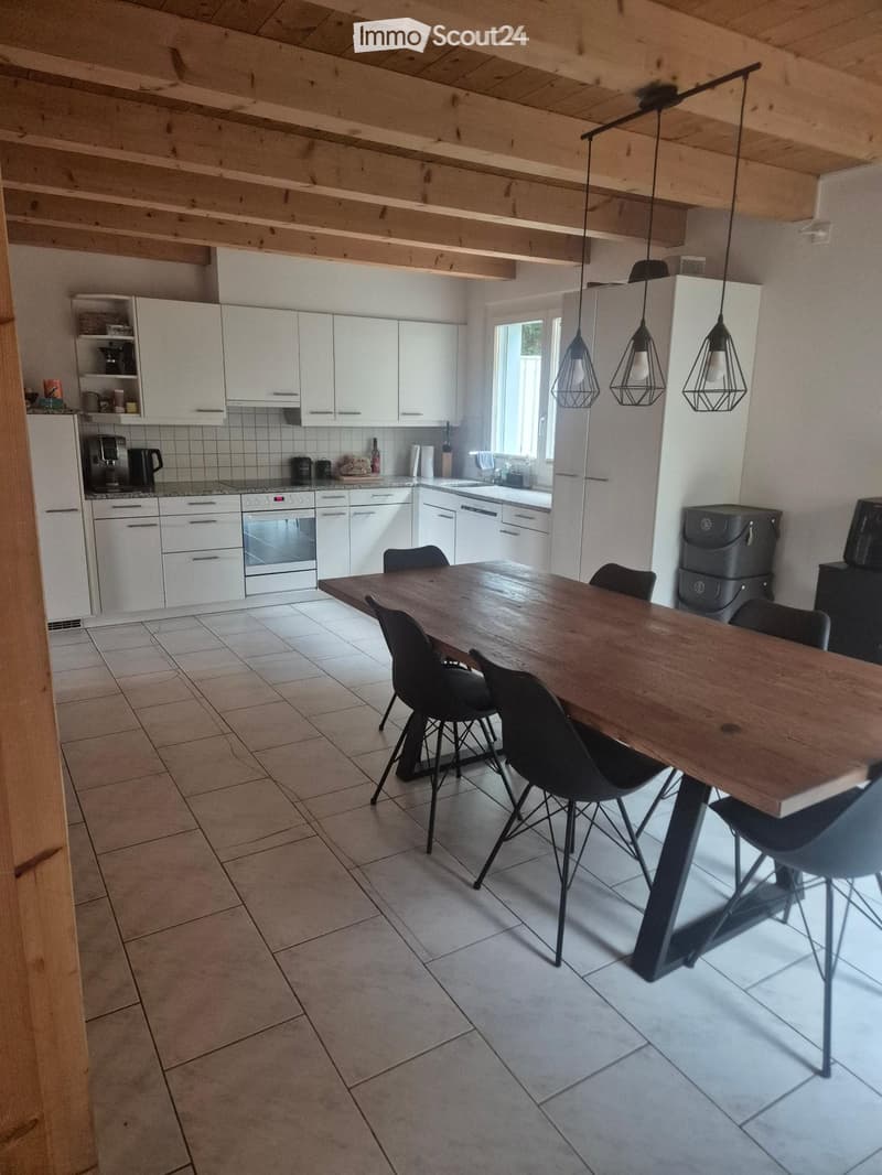 kitchen with dining area, wooden dining table, black chairs, white cabinets, tiled floor, hanging lamps, kitchen appliances