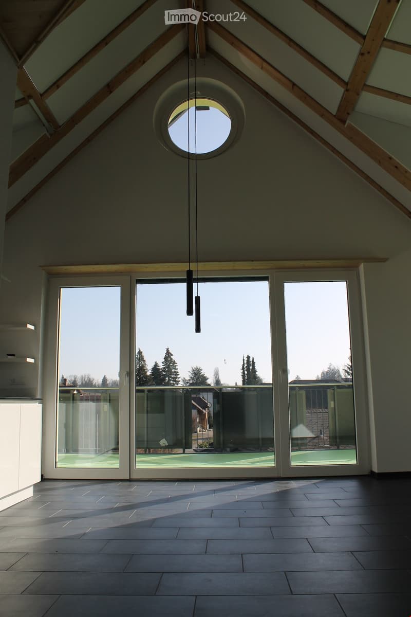 Unfurnished Room. Empty room with wooden beams, glass doors, and a circular window. Tiled floor.