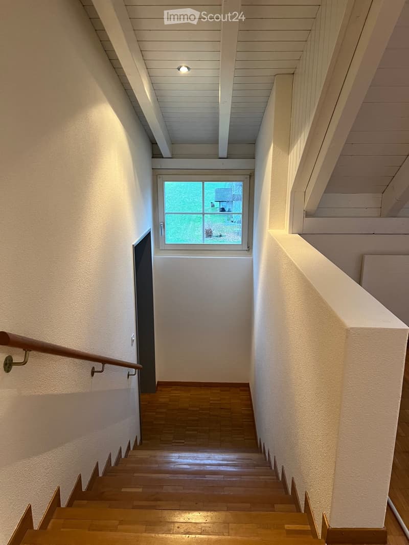 wooden stairs, white walls, white ceiling, window, wooden handrail
