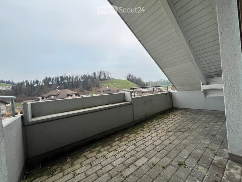 Balcony with brick floor, concrete walls, metal railing, view of the landscape