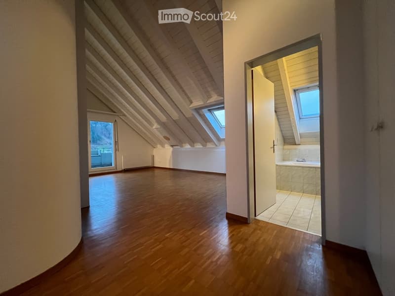 empty attic room, wooden floor, white walls, two windows, bathroom with bathtub
