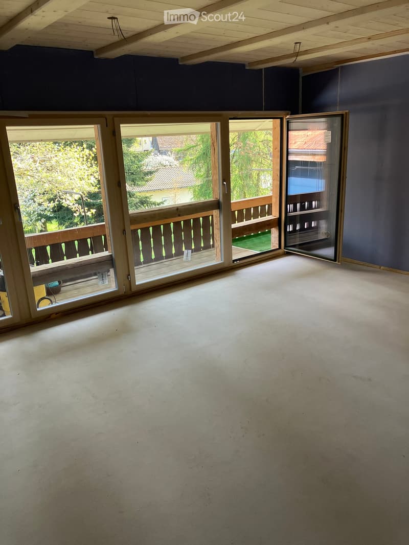 Unfurnished Room. Empty room with large windows and sliding glass doors leading to a balcony. Wooden ceiling and floor.