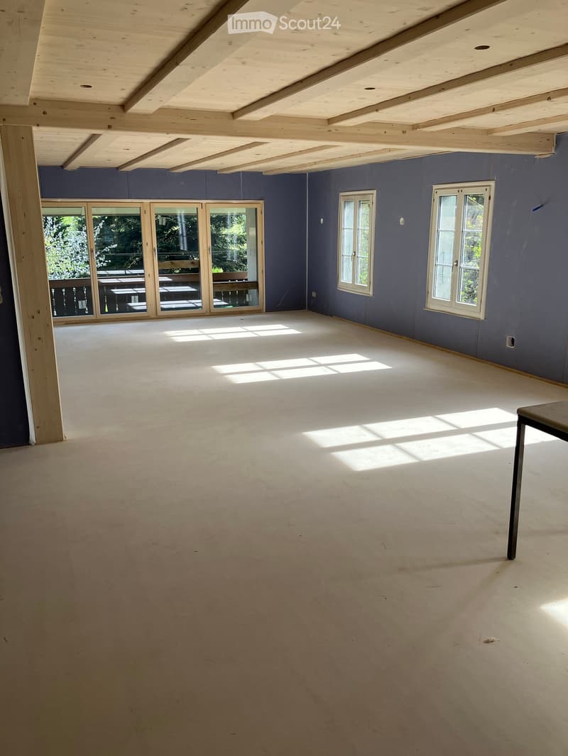 Unfurnished Room. An empty room with a wooden ceiling, white walls, and a white floor. There are three windows with wooden frames and a wooden table in the corner.