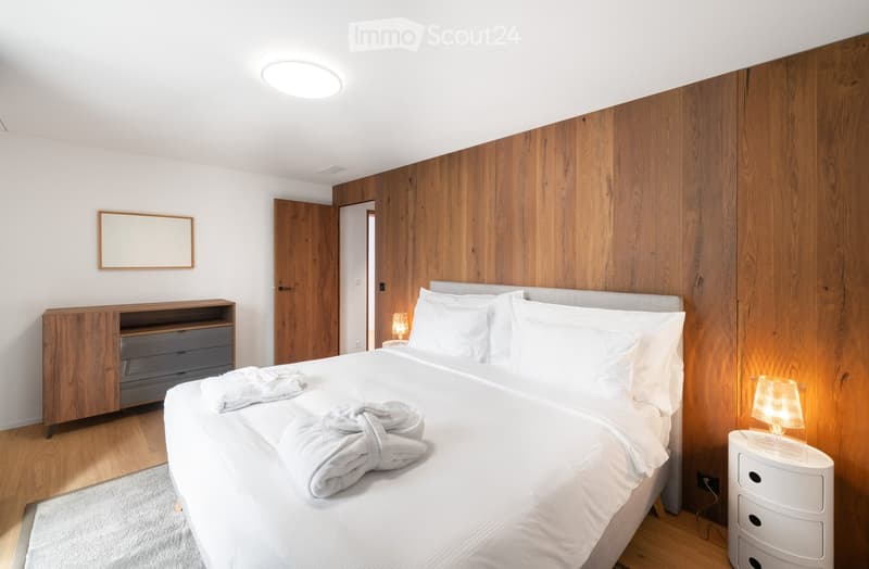 wooden walls, wooden floor, white bedding, night lamp, wooden wardrobe, rug