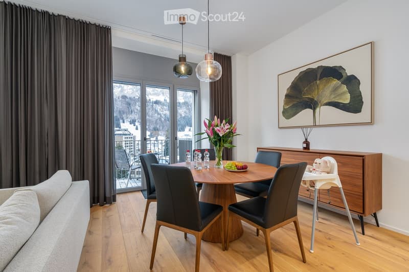 round wooden table, wooden chairs, modern decor, large glass doors to balcony