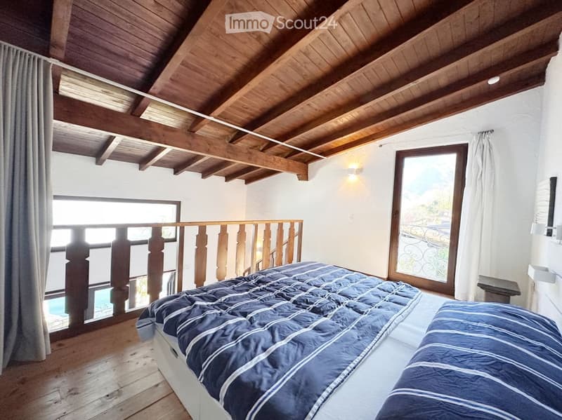 bedroom with wooden ceiling, wooden floor, bed, balcony, window, view