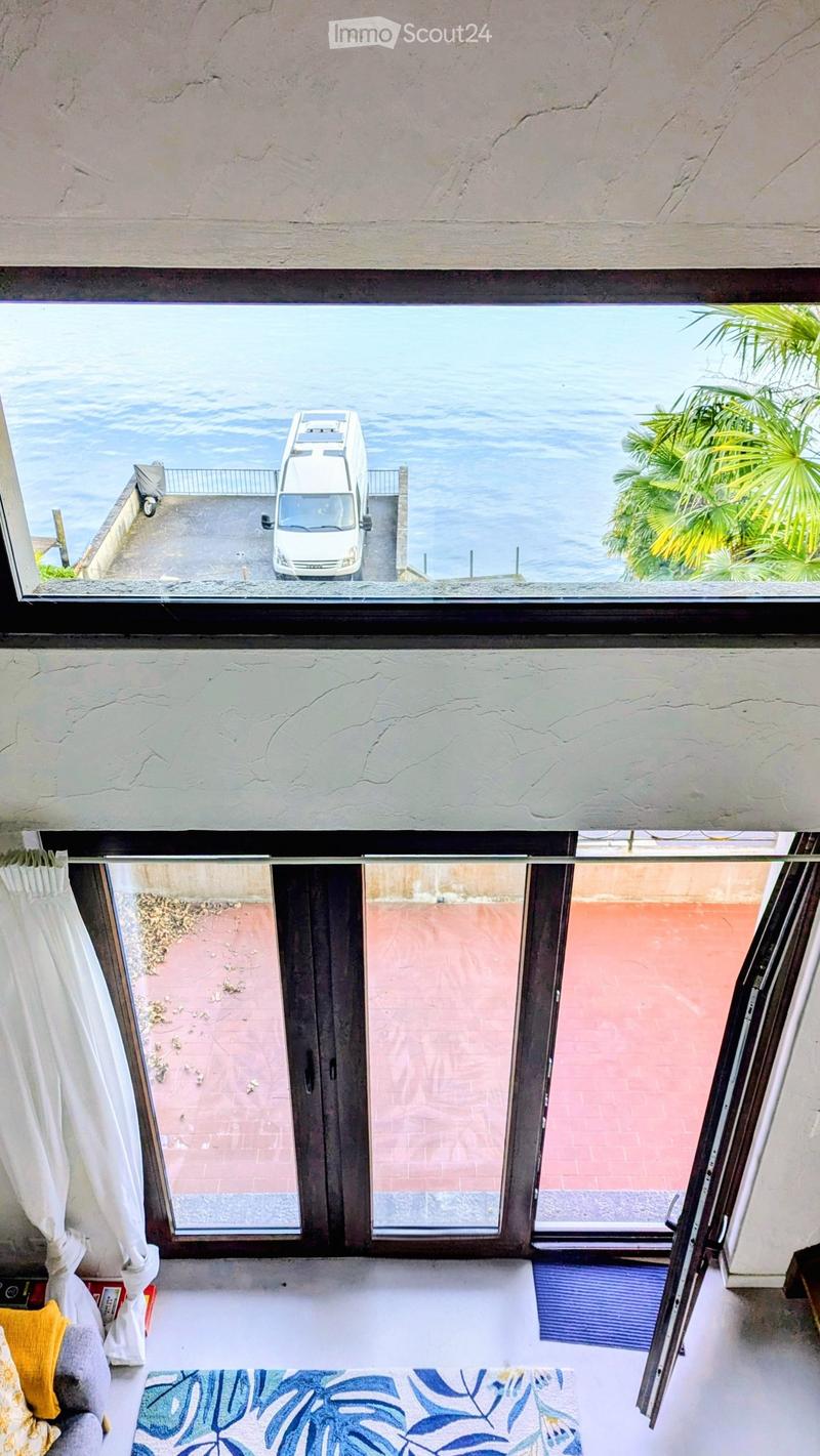 large windows, view of the sea, balcony, rug, couch