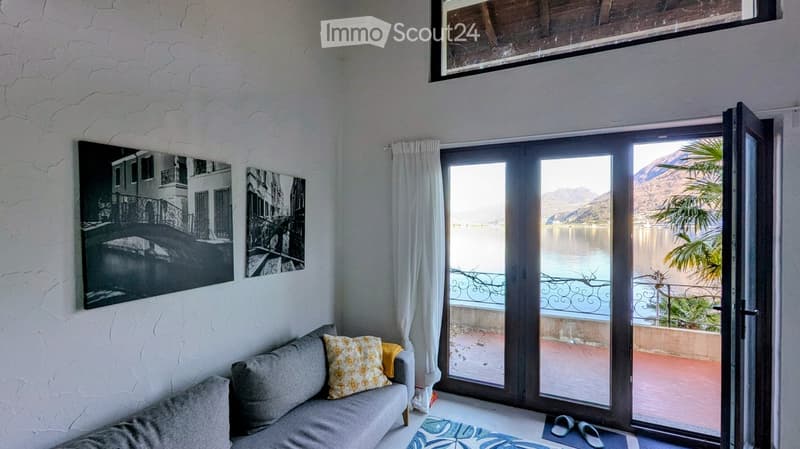 gray couch, two pillows, rug, sliding glass doors, balcony, lake view