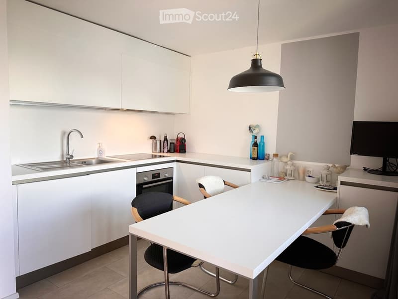 modern kitchen, white cabinets, stainless steel appliances, white countertops, black chairs, white table, pendant light