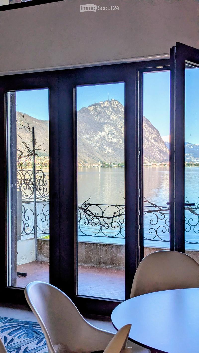 Dining room with large windows, balcony, lake view, modern chairs, round table