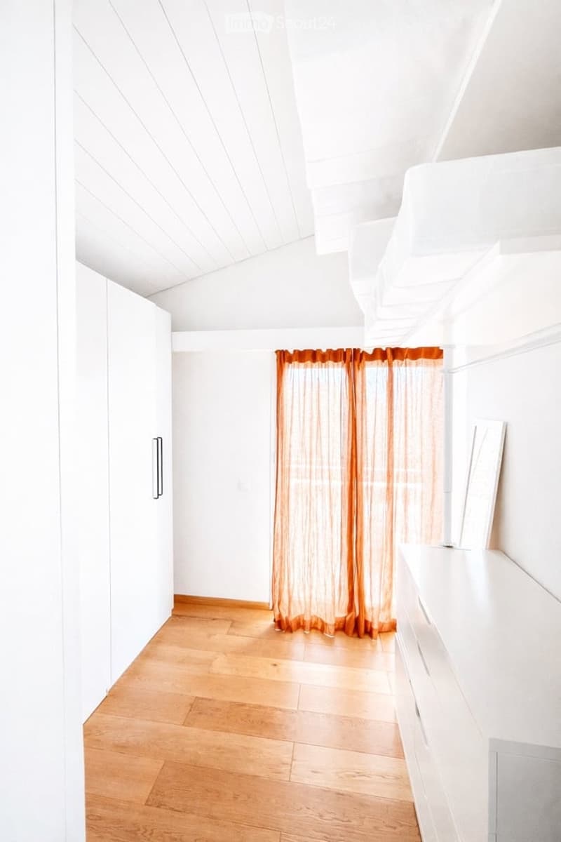 white walls, wooden floor, white cabinets, orange curtains