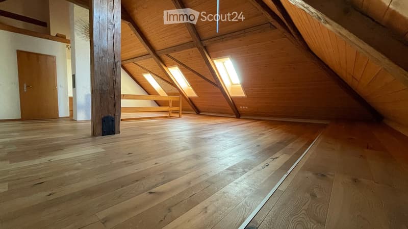 Wooden floor, wooden ceilings, white walls, wooden benches, attic windows