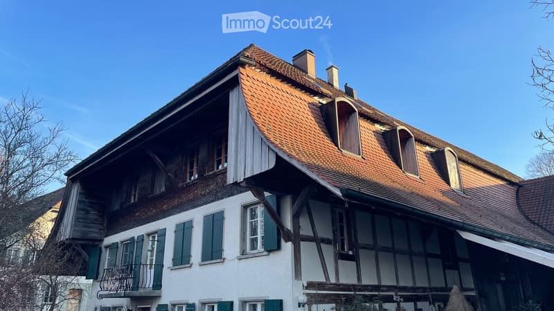 3 story house, white walls, wooden beams, red tiles, balcony, multiple windows
