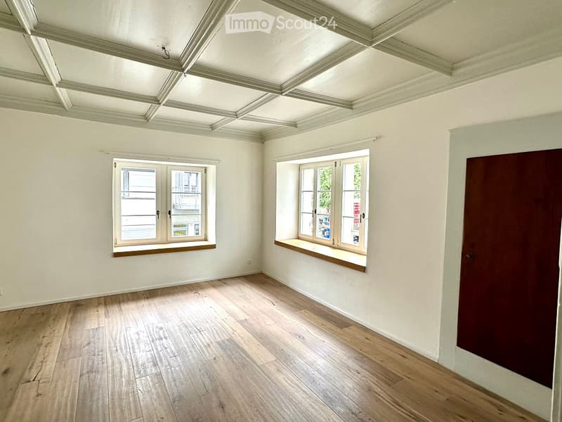 empty room, wooden floor, white walls, two windows, wooden door, wooden window sills