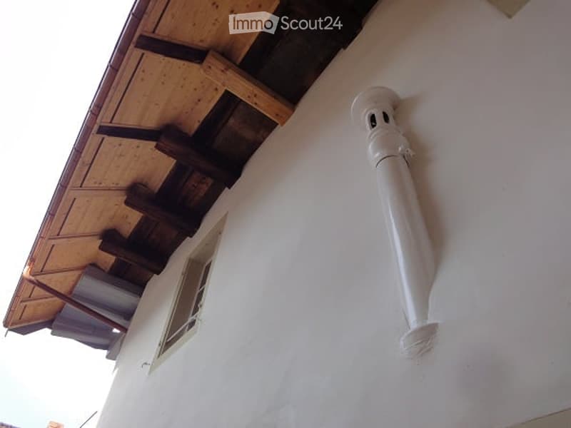 white pipe attached to the side of a white wall