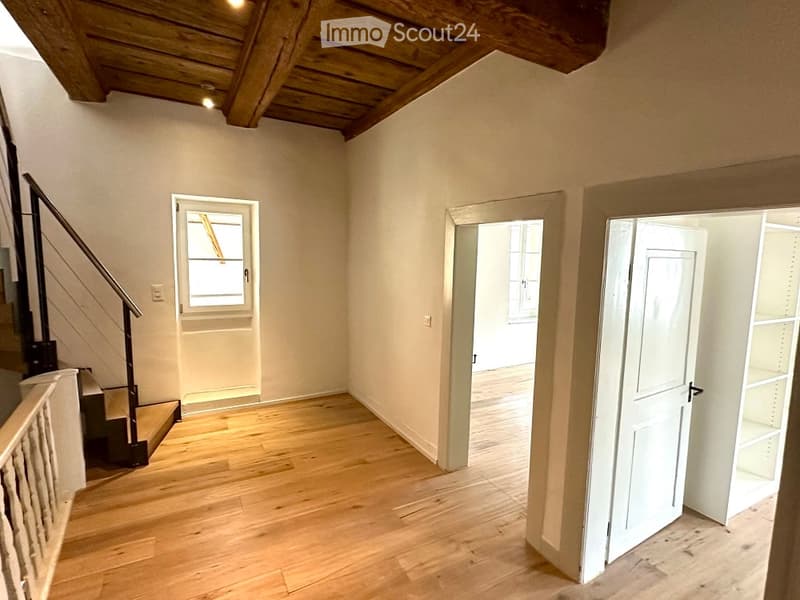 Empty room with wooden floor, open doors, staircase and ceiling, glass window