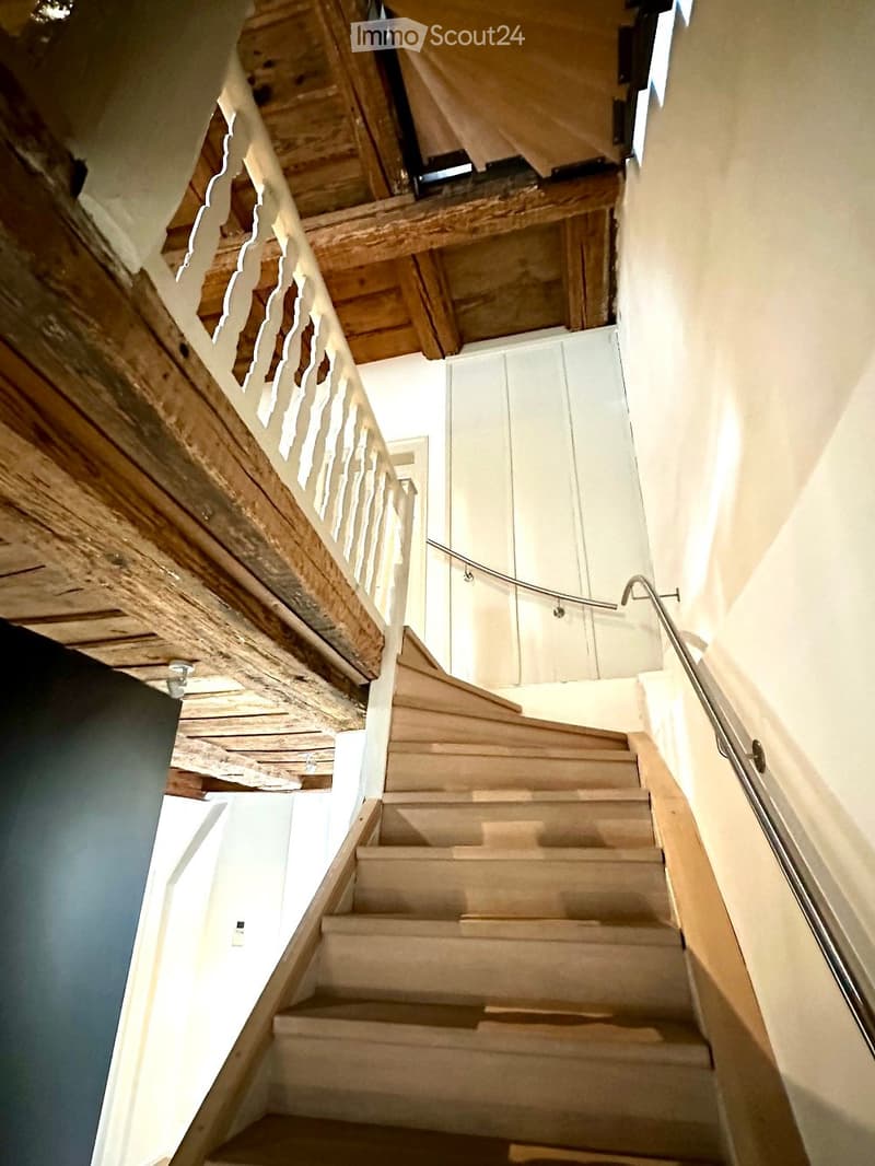 wooden staircase, wooden handrail, metal handrail, light beams, wooden ceiling